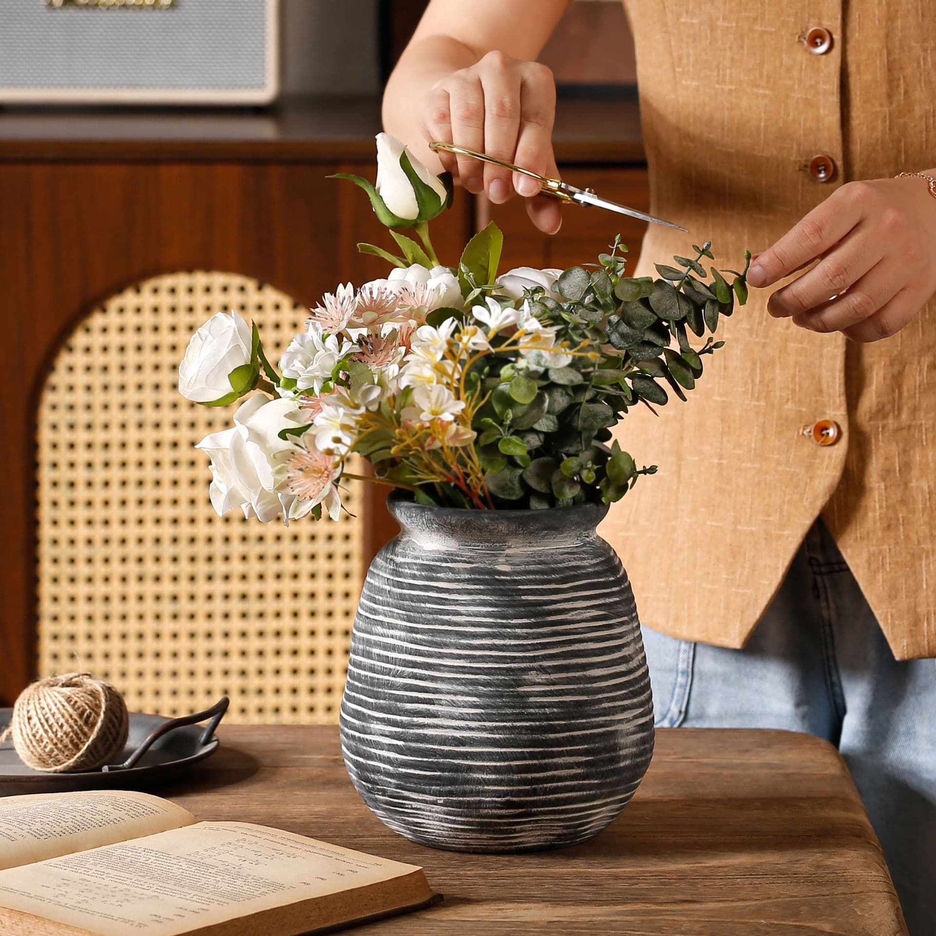 Horizontal ribbed ceramic vase being arranged with white flowers